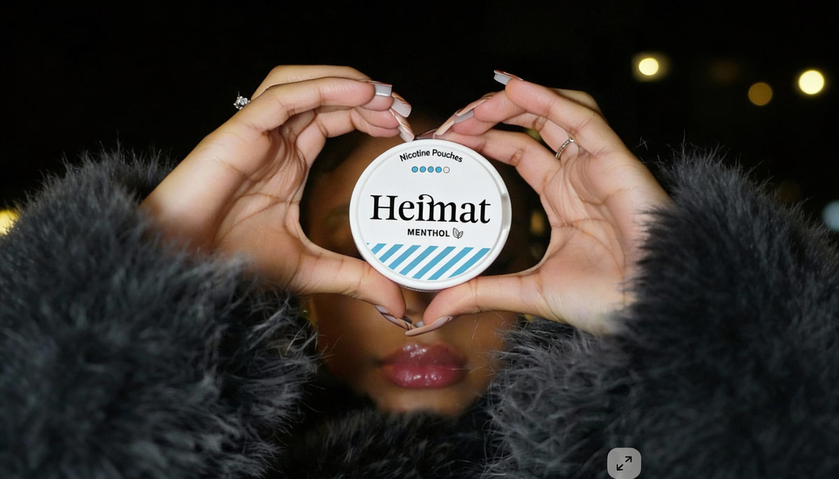 Dosis de Heimat Menthol Nicotine Pouches en forma de corazón sostenida, fotografía de estilo de vida con mujer en abrigo negro